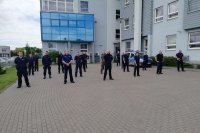 Policjanci wykonujący pompki na wewnętrznym parkingu KPP w Zduńskiej Woli, aby wesprzeć akcję pomocy chorego na SMA Wojtka Howisa z Galewic