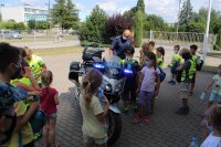 Naczelnik WRD KPP w Zduńskiej Woli pokazuje dzieciom motocykl policyjny
