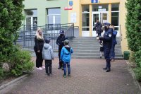 Policjanci rozdają elementy odblaskowe przy szkole w miejscowości Czechy w gminie Zduńska Wola