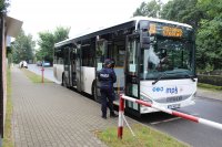 policjantka stojąca przy autobusie szkolnym przewożącym dzieci