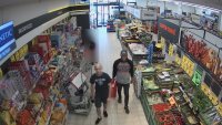 Aleja w sklepie samoobsługowym, którą idą dwaj młodzi mężczyźni, których wizerunek zarejestrowała kamera monitoringu.