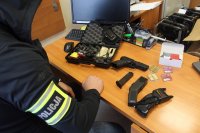 Policjant rozłożył na biurku broń gazową, dwa paralizatory i walizkę od broni.