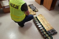 Policjant ubrany w żółtą odblaskową kamizelkę rozłożył 59 kaw na podłodze i będzie je spisywać.