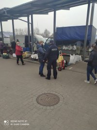 policjant rozmawiąjący z mieszkańcami podczas kontroli targowiska