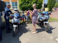 Dzieci z policjantem wydziału ruchu drogowego przy policyjnych motocyklach