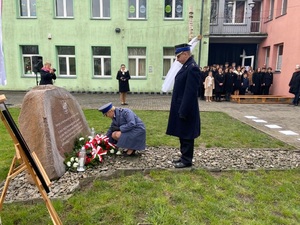 Inspektor Małgorzata Mączyńska składa kwiaty pod tablicą pamiątkową