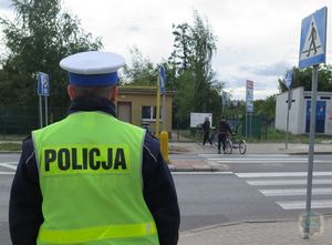 Policjant stoi przed przejściem dla pieszych.