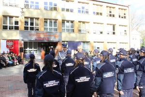 Zastępca Komendanta Powiatowego Policji w Zduńskiej Woli wręczający legitymacje uczniom klas mundurowych