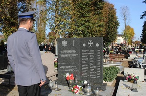 Zastępca Komendanta Powiatowego Policji w Zduńskiej Woli młodszy inspektor Benedykt Andrzejak składa kwiaty przed tablicą pamiątkową upamiętniającą poległych policjantów.