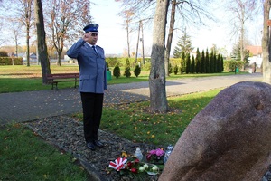 Zastępca Komendanta Powiatowego Policji w Zduńskiej Woli młodszy inspektor Benedykt Andrzejak składa kwiaty przed tablicą pamiątkową upamiętniającą poległych policjantów.