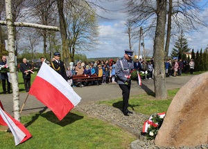 Komendant zduńskowolskiej komendy składa kwiaty pod tablicą