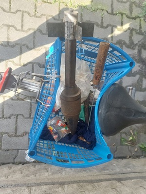 Pocisk w plastikowym, niebieskim koszyku rowerowym, obok kilka innych, drobnych rzeczy.