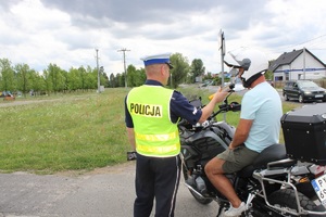 Policjant sprawdzający stan trzeźwości kierującego motocyklem.