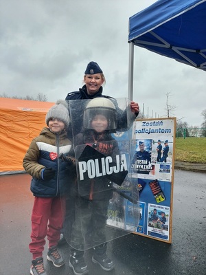 Policjantka pozuje do zdjęcia razem z dwójka dzieci.
