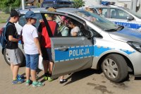 Uczniowie Szkoły Podstawowej w Janiszewicach wsiadają do policyjnego radiowozu.