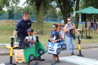 policjant uczy dzieci bezpiecznych zachowań na drodze