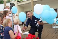 Policjant rozdaje dzieciom balony