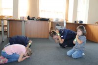 Sierżant sztabowy Kamila Sowińska uczy dzieci pozycji bezpiecznej w kontakcie z agresywnym zwierzęciem tak zwany &quot;Zółwik&quot;