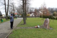 Zastępca Komendanta Powiatowego Policji w Zduńskiej Woli oddaje honor do pamiątkowej tablicy przy Szkole w Wojsławicach