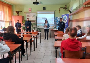 Klasa szkolna, w ławkach siedzą słuchacze, trzej funkcjonariusze i nauczycielka szkoły, zachęcają do nauki w klasie mundurowej w ZSRCKU w Wojsławicach.