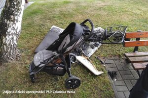 Na trawniku stoi spalony spacerowy wózek.