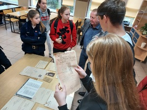 Uczniowie oglądają archiwalne dokumenty przywiezione na lekcję historii.