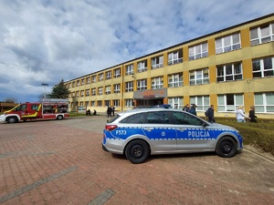 Radiowóz na tle szkoły w Wojsławicach