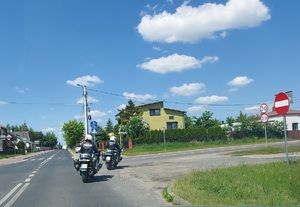 Dwaj policjanci jadą na motorach, skręcają w prawą stronę.