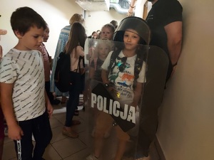 Dzieci przymierzają ubranie bojowe policjantów oddziału prewencji