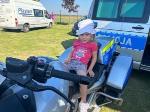 Dziewczynka siedzi na policyjnym motocyklu