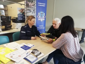Policjantka i pracownik ZUS podczas rozmowy z seniorem.