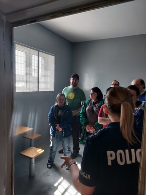 Policjantka pokazuje pomieszczenie dla osób zatrzymanych