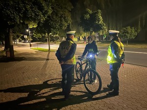 Dwaj policjanci, rozmawiają z rowerzystą