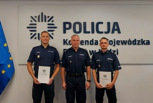 Do zdjęcia pozują dwaj zduńskowolscy policjanci, trzymają w dłoniach listy gratulacyjne, a między nimi stoi inspektor Robert Krawczyk.