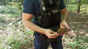 Policjant pokazuje znaleziony granat.