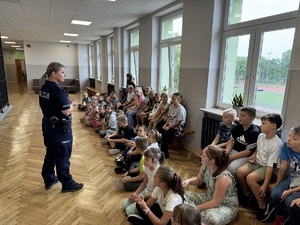 Policjantka w mundurze prowadząca prelekcję z uczniami w Szkole Podstawowej w Czechach.