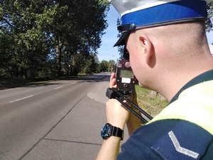 Policjant ruchu drogowego dokonujący pomiaru prędkości.