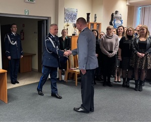 Aula w komendzie. W drzwiach stoi komendant, a dowódca uroczystości wita wchodzącego komendanta.