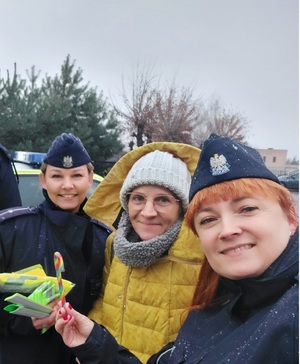 Dwie policjantki i kobieta, pozują uśmiechnięte do zdjęcia.