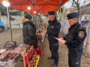 Kontrola stoiska z fajerwerkami przeprowadzona przez policjanta i strażnika miejskiego.