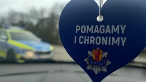Zapach samochodowy w kształcie serduszka wisi pod lusterkiem kierowcy. Na zapachu napis: pomagamy i chronimy.