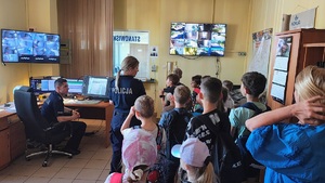 Dzieci oglądają dyżurkę, słuchają co mówi do nich policjantka.