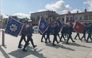 Przez plac maszerują poczty sztandarowe jednostek policji.