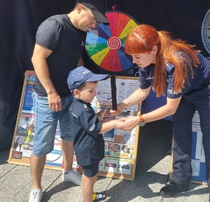 Policjantka zakłada chłopcu na rękę odblask.