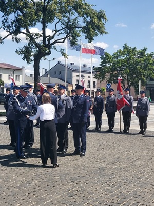 Na środku placu stoi kilku policjantów, którzy otrzymują medale.