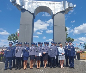 Grupowe zdjęcie policjantów pod pomnikiem.
