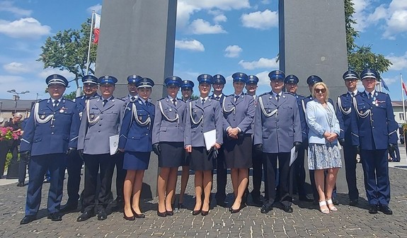 Zduńskowolscy policjanci pozują grupowo do zdjęcia pod pomnikiem.