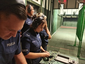 Policjant i policjantka wkładają naboje do magazynków.