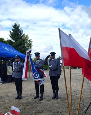 Policyjny poczet sztandarowy oddaje hołd pod pomnikiem.