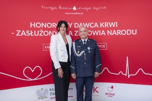 Do zdjęcia pozuje kobiet i policjant.
